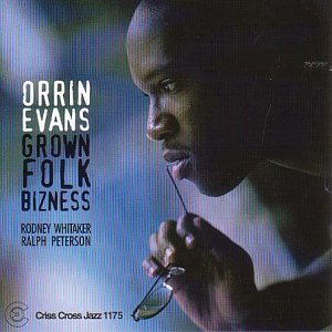 "Orrin Evans album cover with a man holding glasses against a blue background."