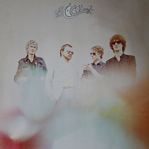 "CD cover with four men and 'Cocoon' logo on a misty background."