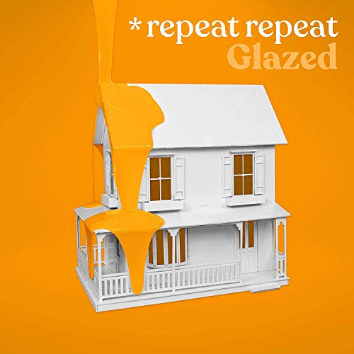 The image depicts a white house model being glazed with orange paint. For accessibility purposes, a suitable alt text could be: "White house model covered in dripping orange glaze."
