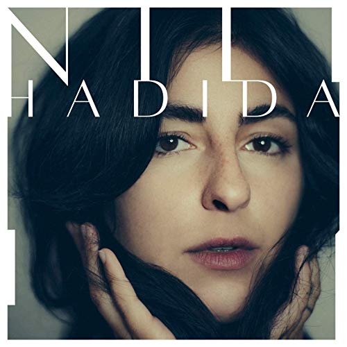 A woman with dark hair and hands on her face, album cover.