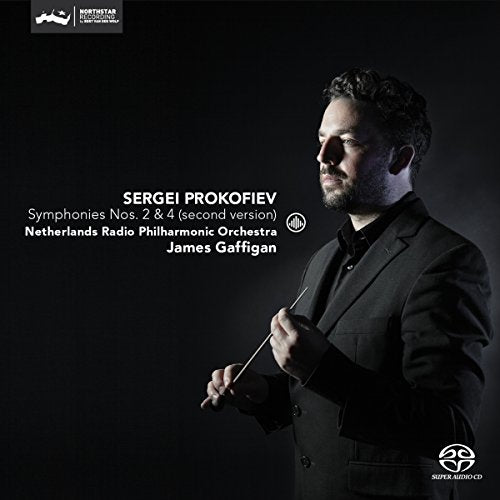 Conductor James Gaffigan in a black suit holding a baton, on a dark background.