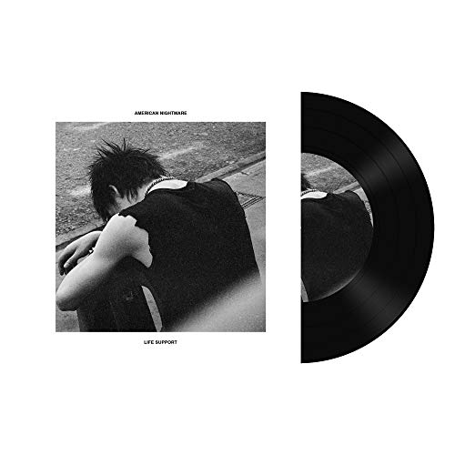 Black vinyl record with album cover showing a person sitting on the ground.