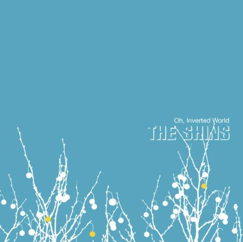 "Album cover with white branches and yellow ornaments on blue background, featuring 'The Shins' text."