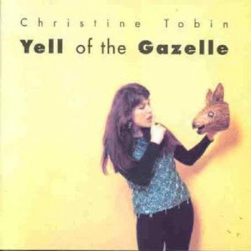 "Album cover with a woman holding a gazelle mask, against a yellow background."