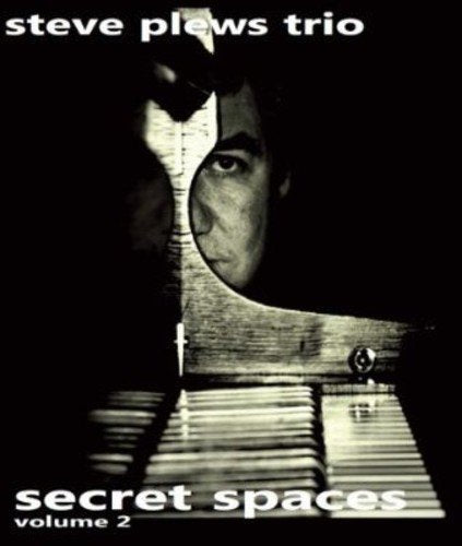 "Album cover with a man's face peering over a piano keyboard on a black background."