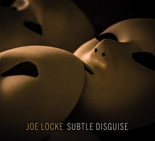 "CD cover featuring three beige masks against a dark background with artist and album name."