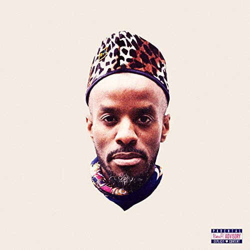 The image depicts a man wearing a leopard-print hat and colorful scarf against a beige background.