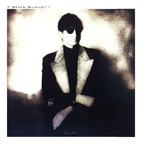 A monochrome album cover featuring a man in a suit, wearing sunglasses, with a white background.