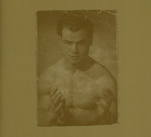 The image is a sepia-toned photograph of a shirtless man with his fists up. For accessibility purposes, a suitable alt text could be: "Sepia-toned photo of a man with fists up, shirtless."