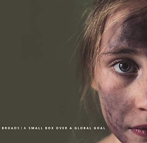 A close-up of a girl's face with dirt on her cheek and forehead.