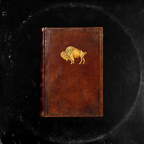Brown leather-bound book with gold bison emblem on the cover, on a black background.