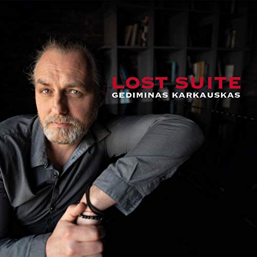 "Album cover featuring a man with a grey beard and a dark shirt."