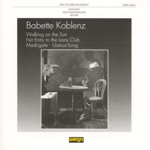 CD cover with black-and-white photo of a table and chair in a dimly lit room.