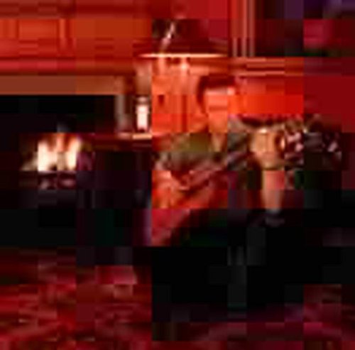 The alt text for the image is: "Blurry image of a man playing guitar by a fireplace."