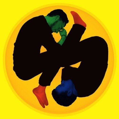 The image is a vinyl record cover featuring two people in a circular frame. Here is a concise description of the image in 15 words or less: "Two silhouetted figures in a yellow circular frame, with contrasting colored heads and feet."