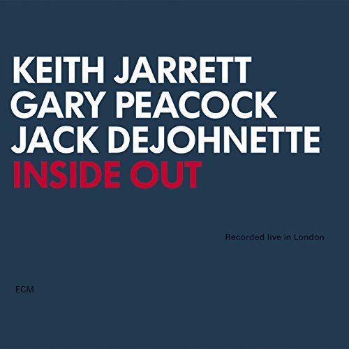 "Album cover with dark blue background, white and red text, featuring artist names and title."