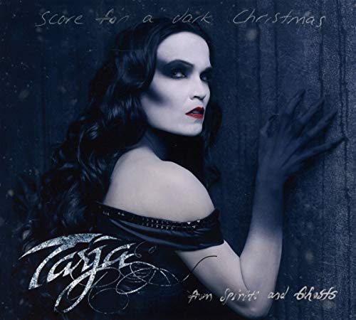 Dark-haired woman with pale skin and red lips against a dark background, wearing black clothing.