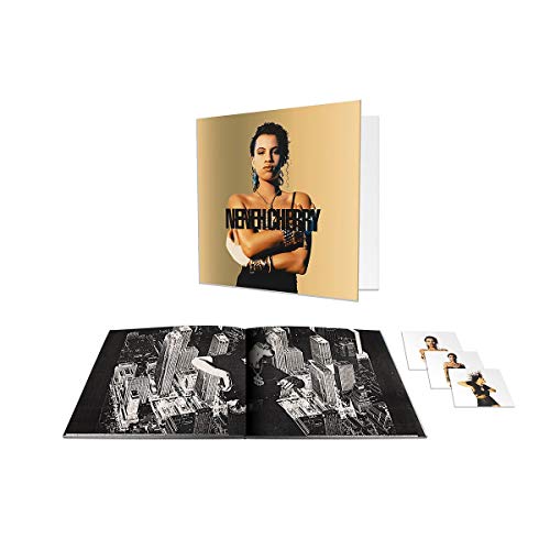 "Vinyl record sleeve with woman's image, booklet, and small photos on white background."