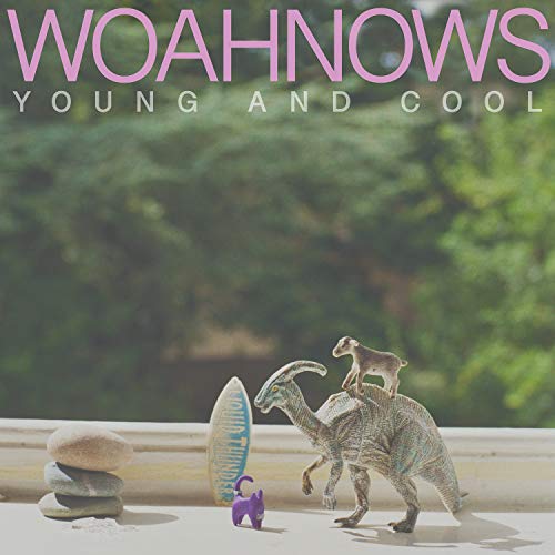 "Vinyl record cover with toy dinosaurs and surfboard on a windowsill, greenery in background."