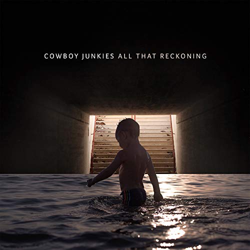 "Album cover: a boy wading in water, with stairs in the background."