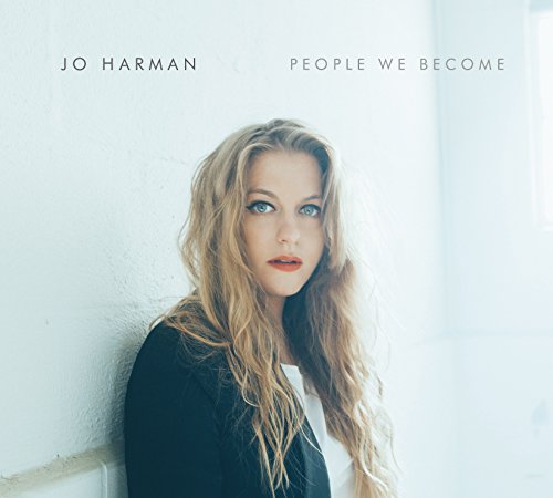 The alt text for the image is: "Album cover featuring a woman with long blonde hair against a white wall."