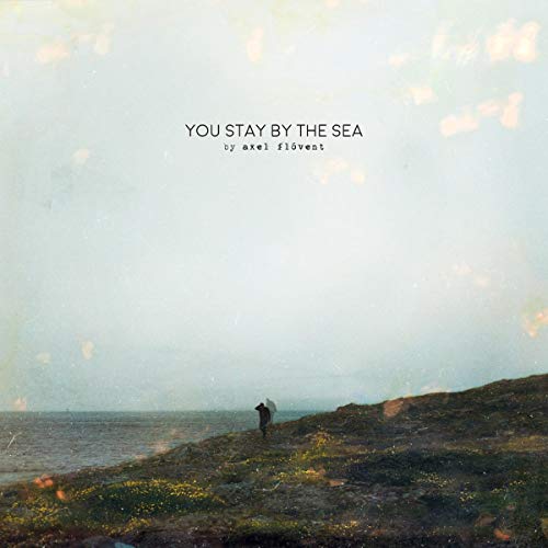 "Album cover featuring a person standing on a rocky seaside cliff, looking out."