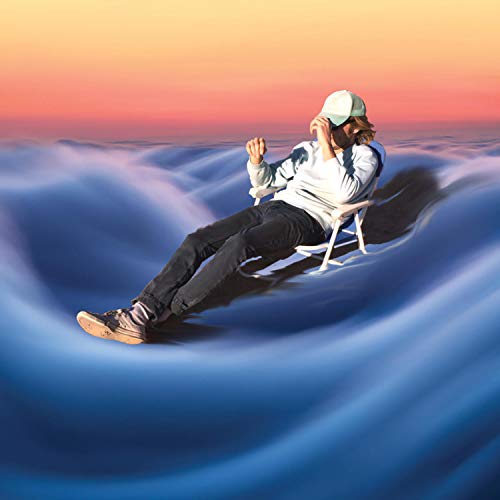 A man sits in a chair, surrounded by swirling blue waves, at sunset.