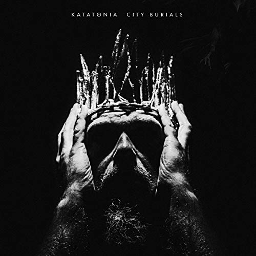 Black and white album cover with a skull wearing a crown, against a dark background.