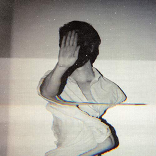 The alt text for the image is: "Black and white photograph of a person covering their face."