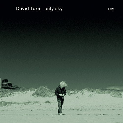 Album cover with a man walking on a beach, house in the background.
