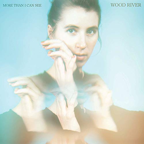 "Album cover with a woman touching her face, blue background, 'Wood River' text."