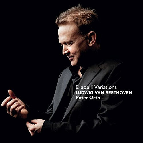"CD cover featuring a man in a black suit against a dark background."