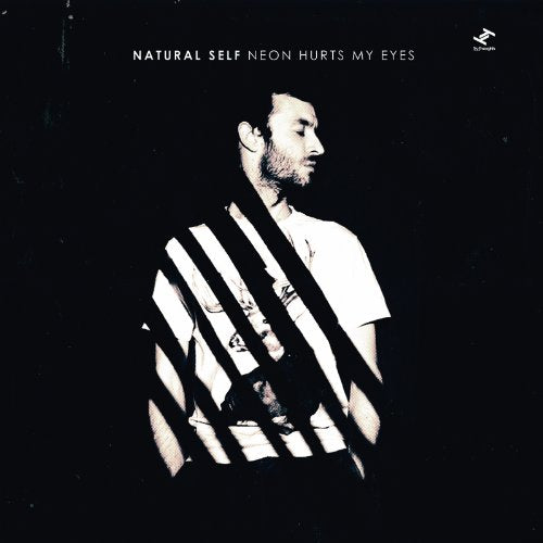 "Album cover featuring a man with striped shadows on a black background."