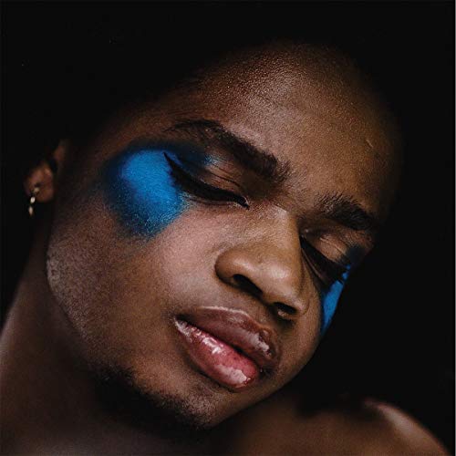 "CD album cover featuring a close-up portrait of a person with blue eye shadow."