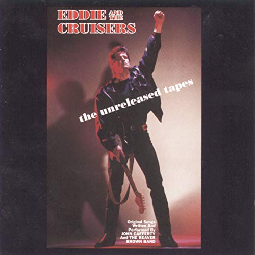 "CD cover with a man in black leather, fist raised, on a red-lit stage."