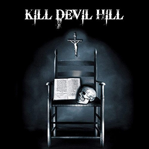 "Album cover with chair, crucifix, Bible, and skull against a dark background."