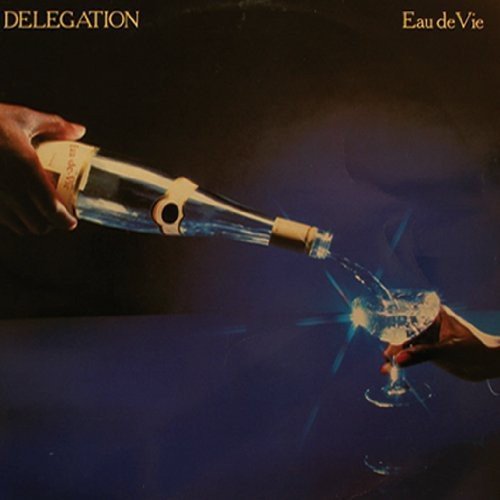 The image depicts a hand pouring liquid from a bottle into a glass. For accessibility purposes, a suitable alt text could be: "Album cover showing a hand pouring liquid into a glass."