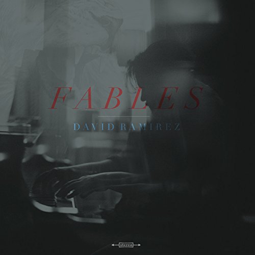 The image depicts a vinyl album cover with a man sitting at a desk. For accessibility purposes, a concise alt text could be: "Vinyl album cover with 'Fables' and 'David Ramirez' text."