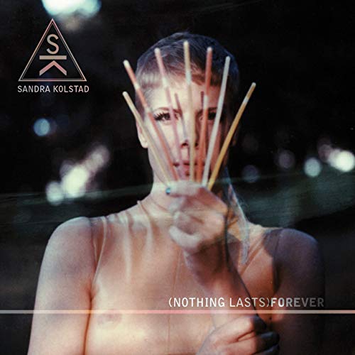 Vinyl album cover featuring a woman holding drumsticks in front of her face.