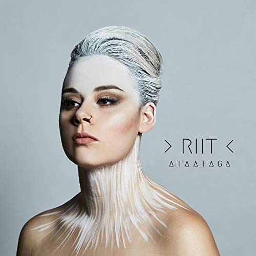 Woman with white hair and painted neck against a gray background, next to text "RIIT ATAATAGA".