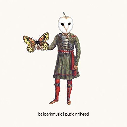 A person with a white owl mask holds a butterfly, wearing a green dress and red boots.