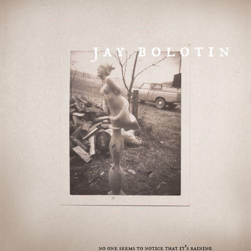 Album cover with sepia-toned photo of nude figure and car, artist name and title.
