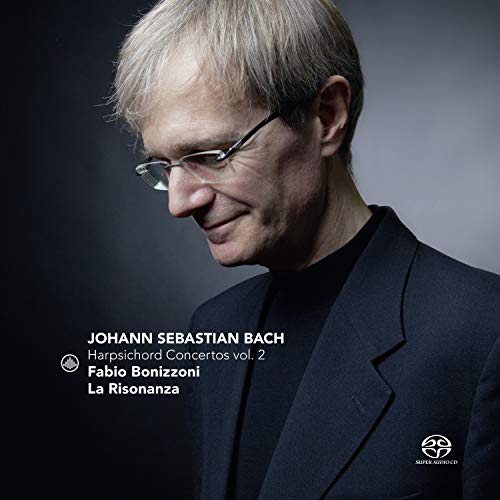 CD cover featuring a man with glasses and a dark suit, against a dark background.