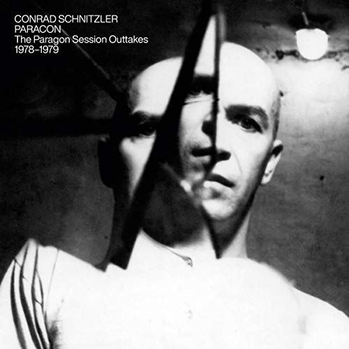 Black and white vinyl album cover featuring a man's face behind metal bars.