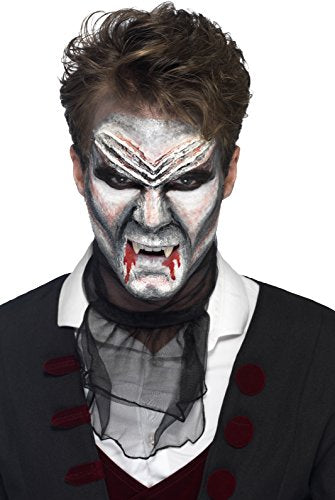 Man dressed as a vampire with pale face, fangs, and blood, wearing formal attire.