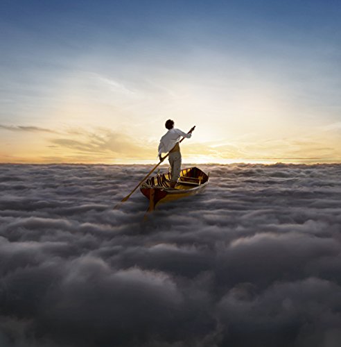 Man in white shirt rows a boat above a sea of clouds at sunset.
