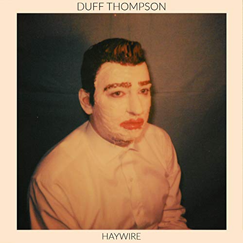"Duff Thompson's album cover for 'Haywire' featuring a man with red lipstick."
