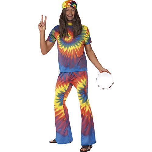 Man wearing tie-dye shirt, flared trousers, and headband, holding tambourine and making peace sign.