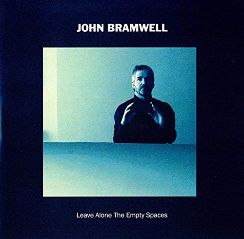 "Album cover with a man in a dark shirt against a blue-toned background."