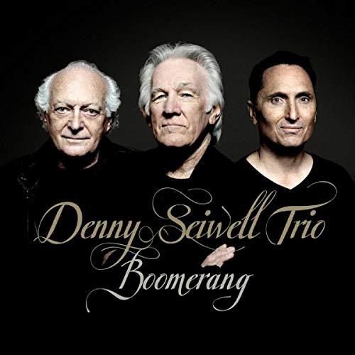 "Album cover featuring three older men in black shirts against a dark background."